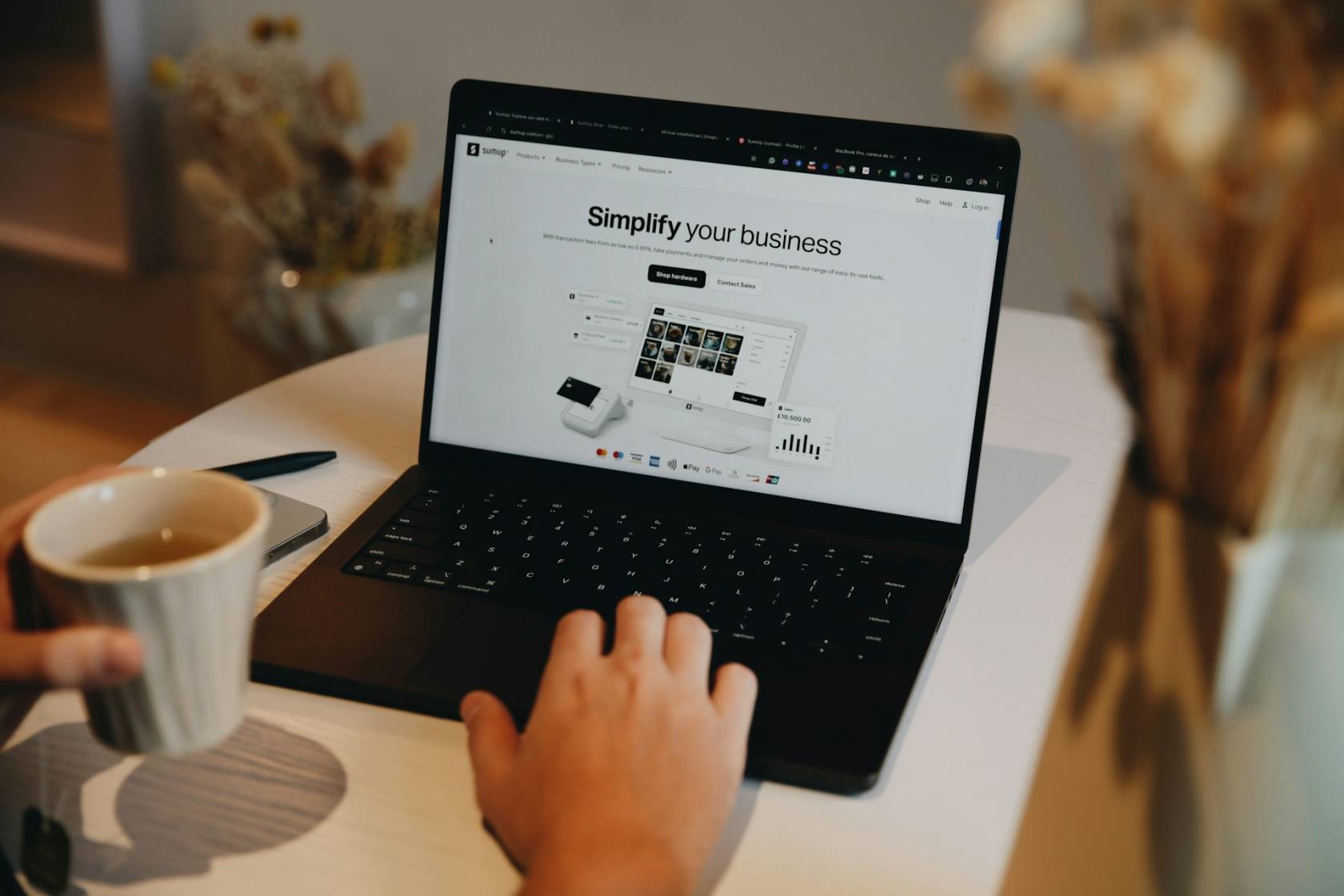 Laptop and coffee cup on table with text "Ssumupts".